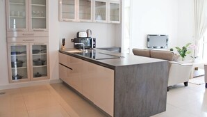 Une cuisine moderne dotée d’un îlot central, de meubles encastrés et d’un coin repas comprenant un canapé et une table.