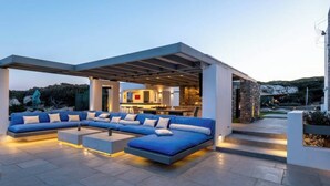 A modern outdoor living area with a sectional sofa, a coffee table, and a pergola structure.