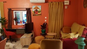 A compact living space with a desk, computer, and a small round table.