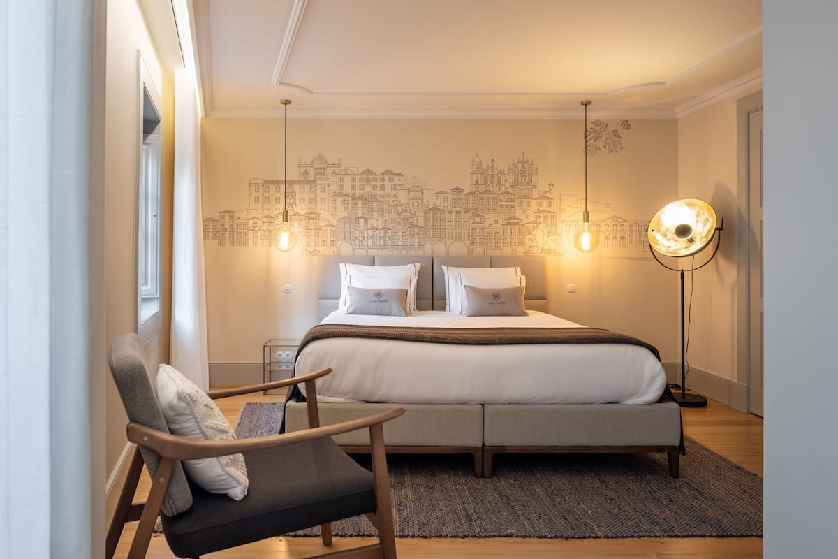 Une chambre moderne avec un grand lit, une chaise et une lampe sur pied.