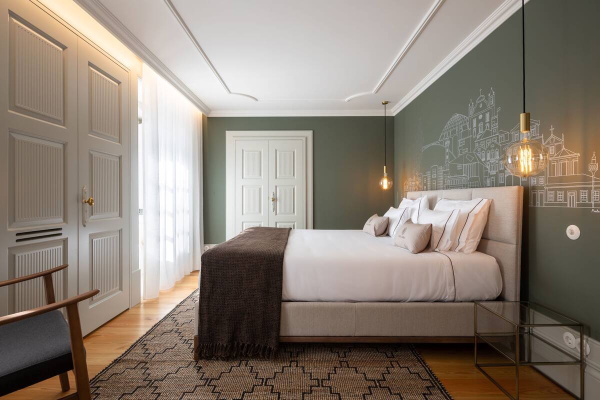 Une chambre à coucher avec un lit, une table de chevet, une chaise et un tapis à motifs.