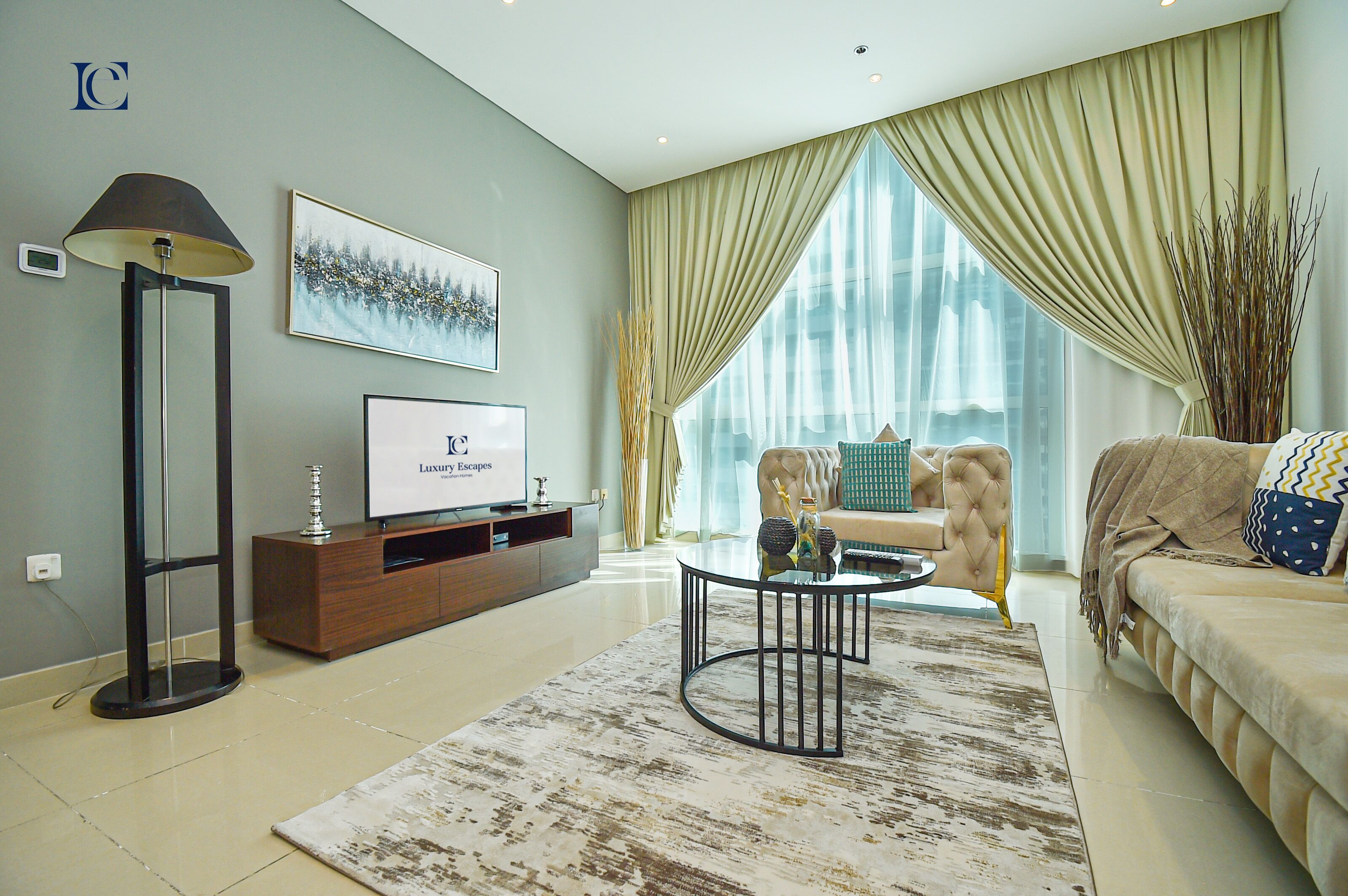 A modern living room with a sofa, a coffee table, and a TV on a wooden stand.