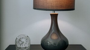 Une table avec une lampe et une horloge.