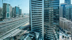 Un immeuble de grande hauteur appelé Millennium Place, composé de nombreux étages, entouré d’autres immeubles imposants et bordé par des autoroutes très fréquentées.