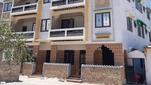 A multi-story building with balconies, a sign indicating it is a business hotel, and a brick facade. - Wiyoni Royals Lamu (Lamu)