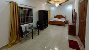 A bedroom with a bed, a desk, a wardrobe, and a ceiling fan. - Wiyoni Royals Lamu (Lamu)