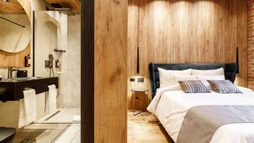 Een moderne slaapkamer met een houten plafond, een groot bed met wit beddengoed en een klein nachtkastje.