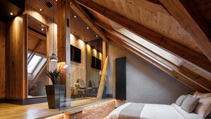 Un dormitorio tipo loft moderno con techo inclinado, vigas de madera, pared de ladrillo decorativa, una cama grande y una pared de vidrio con vistas al exterior.