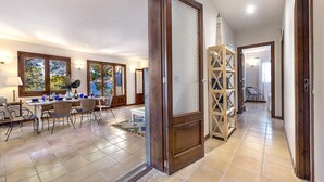 Un espacio habitable amplio con una mesa de comedor, sillas y vistas al exterior a través de amplios ventanales.