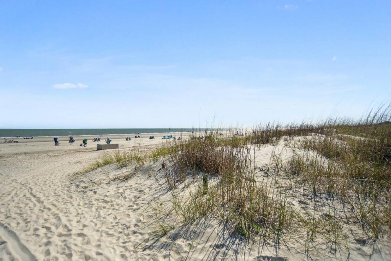 Une plage avec des dunes de sable et un ciel dégagé.