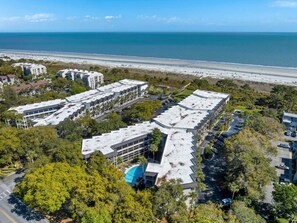 Un complejo hotelero frente al mar con varias edificaciones, zonas de estacionamiento y vistas a la playa.