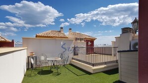 A rooftop terrace with artificial grass, a small table and chairs, and a decorative wall with a logo. - Luxury apartment with spa, 5min. to the sea and golf course (Orihuela Costa)