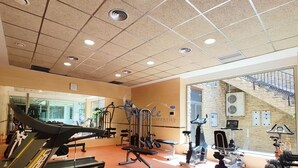 A gym with treadmills, exercise equipment, and a staircase leading to an outdoor area. - Luxury apartment with spa, 5min. to the sea and golf course (Orihuela Costa)