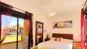 A bedroom with a bed, a nightstand, a mirror, a window with curtains, and a balcony. - Luxury apartment with spa, 5min. to the sea and golf course (Orihuela Costa)