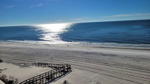 A beach with a wooden boardwalk leading to the water, a sandy shore, and a clear sky. - Penthouse at Paradise 9th Floor (Orange Beach)