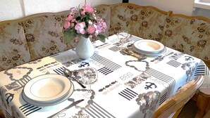 A dining table set with plates, cutlery, and a vase of flowers.