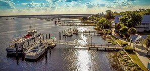 A marina with boats docked, a bridge, and residential buildings along the waterfront.