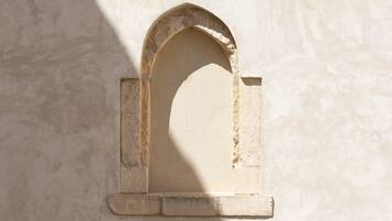 Une arche en pierre à la texture rugueuse et à la surface érodée par les intempéries.