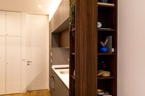 A modern kitchen with a white countertop, wooden cabinets, and a built-in oven.