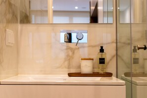 A bathroom with a marble wall, a mirror, a sink, and a shower area. - Studio with a terrace, 250 meters from Praia da Granja (São Félix da Marinha)