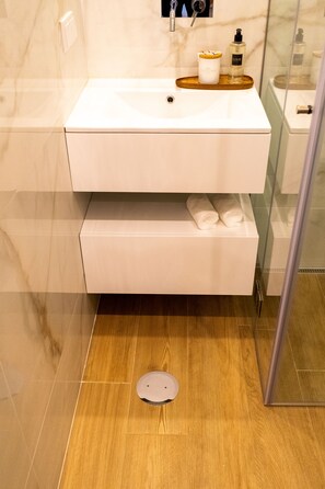A modern bathroom with a white sink, a wooden tray, and a glass shower enclosure. - Studio with terrace, 250m from Praia da Granja (São Félix da Marinha)