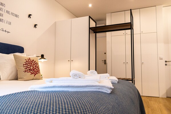 Una habitación de hotel con una cama, un armario y una pared con elementos decorativos.