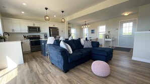 A modern kitchen with white cabinets, stainless steel appliances, and a central island. - Your Perfect Fall Getaway- Only a 5 Minute Walk From Beautiful North Shore Beach (South Rustico)