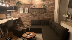 A modern living room with a sectional sofa, a coffee table, and a fireplace.