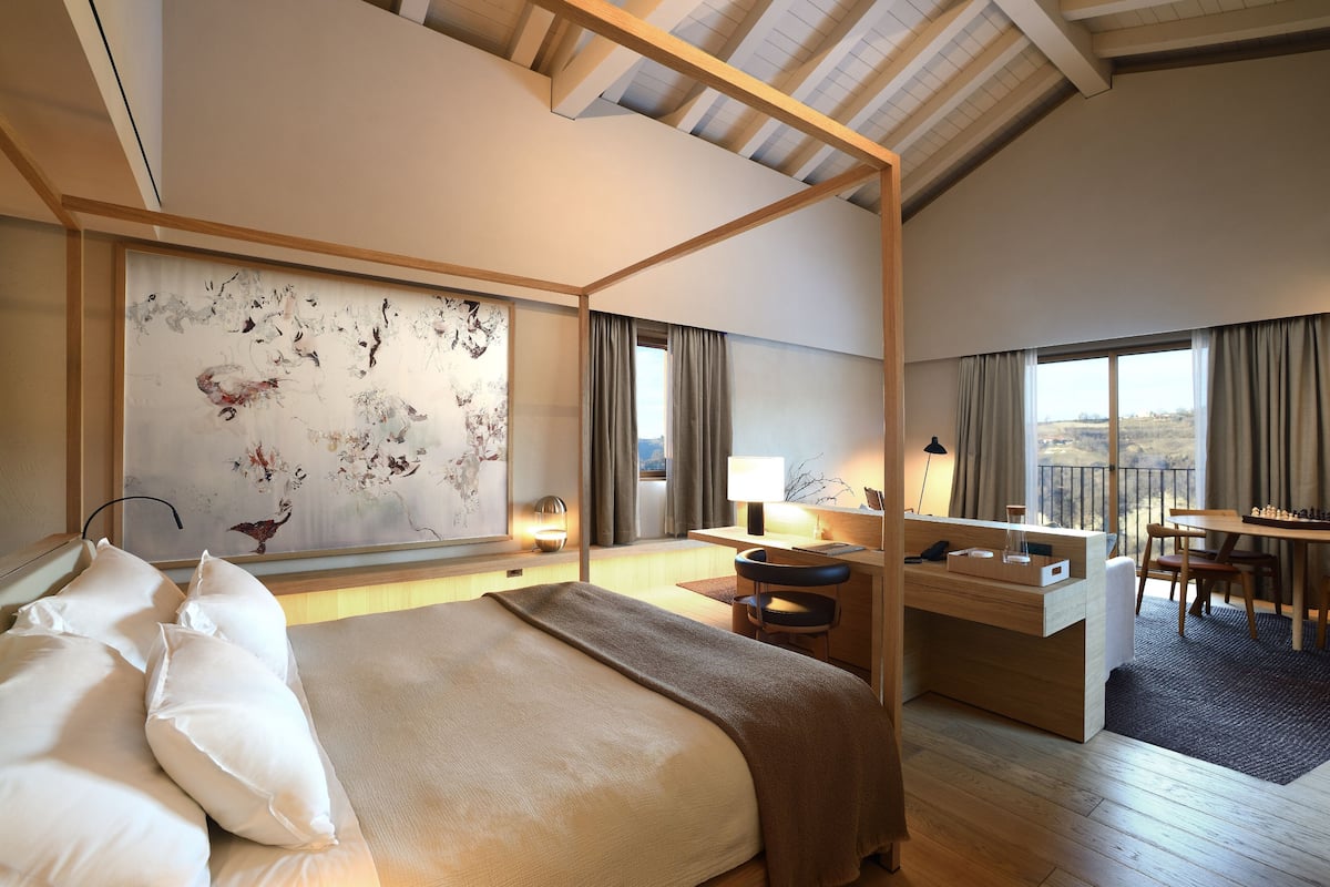 Une chambre d’hôtel moderne, dotée d’un grand lit, d’un bureau et offrant une vue sur l’extérieur.
