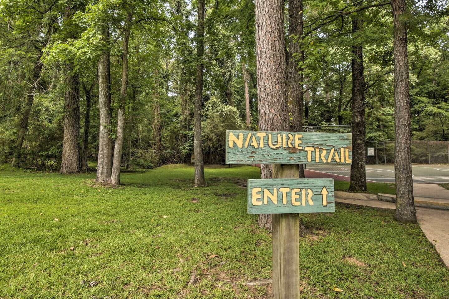A wooden signpost with 'NATURE TRAIL' and 'ENTER' directions in a wooded area.