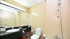Un baño con lavamanos, inodoro y ducha.