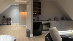 Een compact appartement in moderne stijl, met kitchenette, eethoek en zithoek.