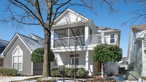 A two-story house with a balcony, a mailbox, and a fire hydrant. - Relax in a Spacious 3 Bedroom + Office- Mud Island/Downtown (Memphis)