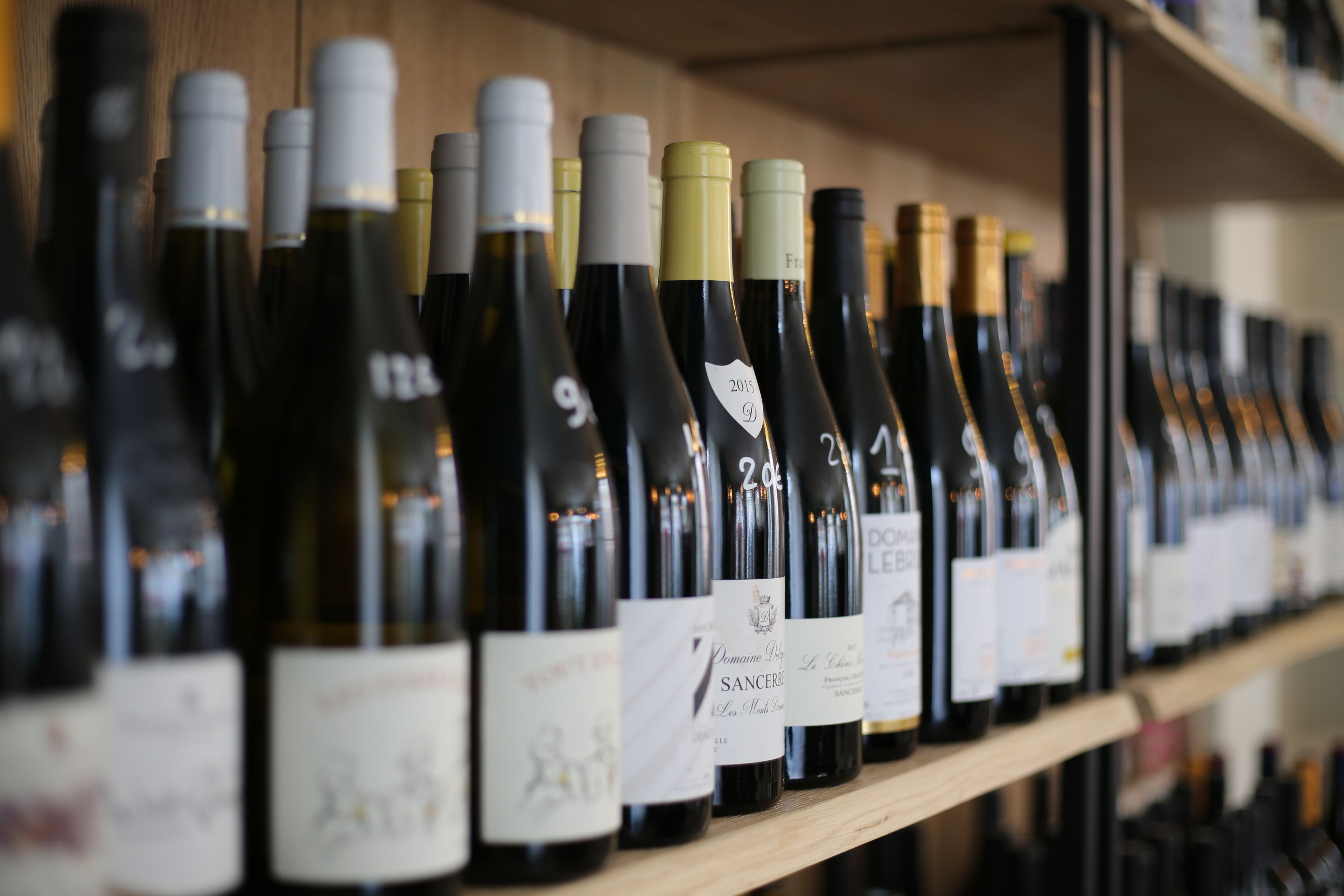 A row of wine bottles on a shelf.