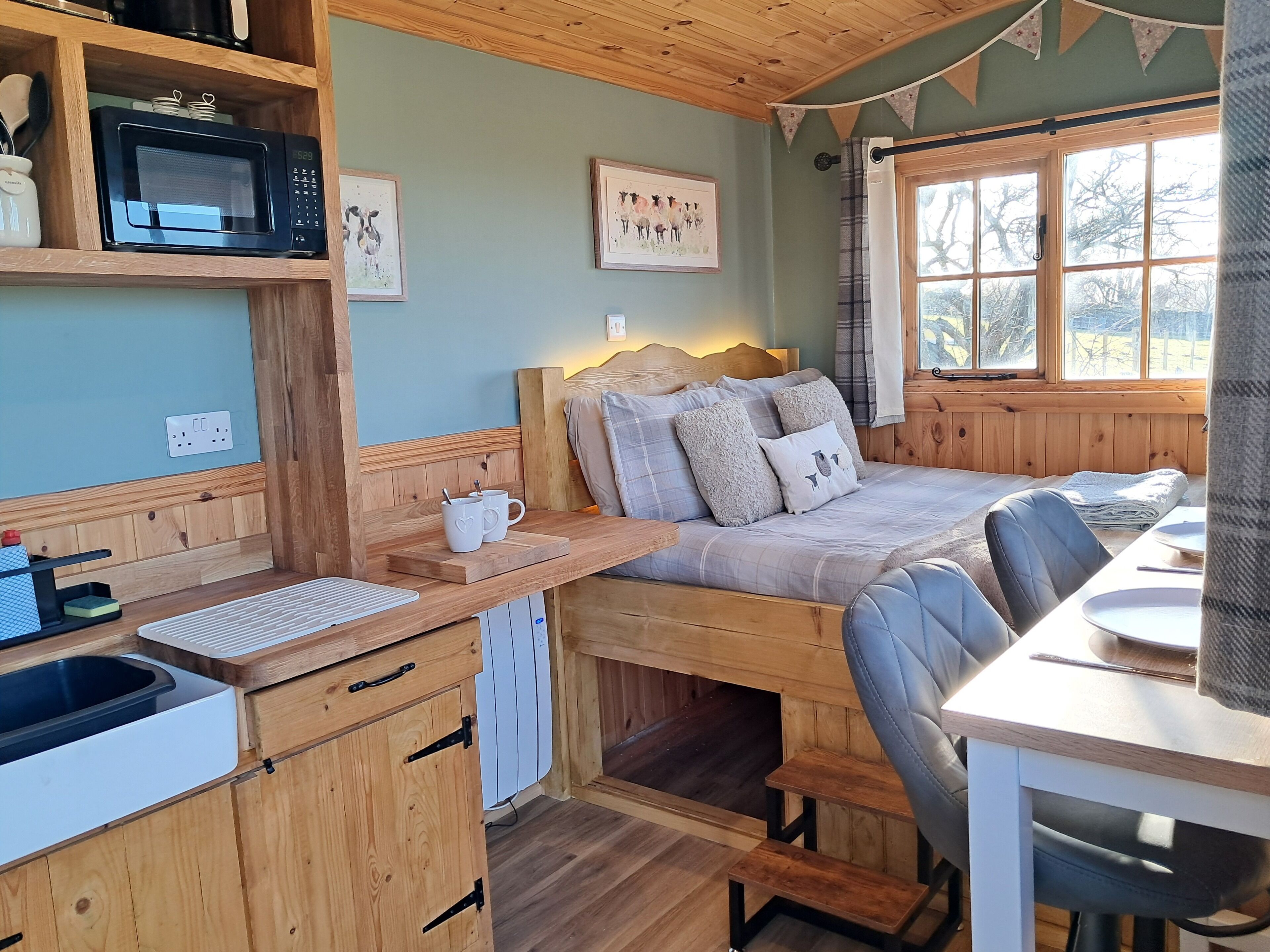 Une chambre confortable, aménagée dans le style d’un chalet, avec un lit, un bureau et une kitchenette.