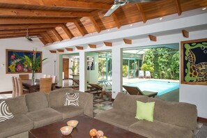 A spacious living area with a pool, wooden ceiling beams, and a view of the outdoors. - 4BR Casa Peces Santa Ana, Private Indoor Pool & Sauna! (Santa Ana)
