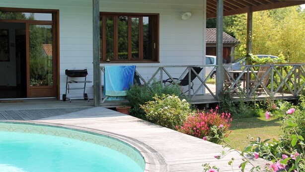 A house with a swimming pool, a covered patio, and a garden with pink flowers. - Family house with swimming pool near Nantes (Vertou)