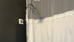 Un baño con bañera, ducha y toallero.