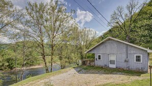 A rustic cabin with a wooden exterior, a front porch, and a small deck. - Cozy Riverfront Cabin (Mendota)