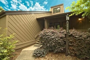 A building with a sloped roof, a porch with steps, and a mailbox. - Fairway Villa 1504 at Rumbling Bald (Lake Lure)