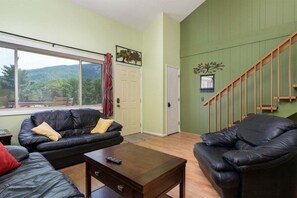 Ein Wohnzimmer mit einer Couch, einem Couchtisch und einer Treppe.