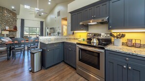 A modern kitchen with dark cabinets, stainless steel appliances, and a granite countertop.
