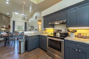 A modern kitchen with dark cabinets, stainless steel appliances, and a granite countertop.