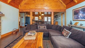 A cozy living room with a wooden ceiling, a sectional sofa, and a coffee table.