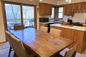 A kitchen with wooden cabinets, a dining table, and chairs.