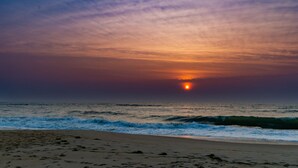 Una playa con olas y un atardecer.