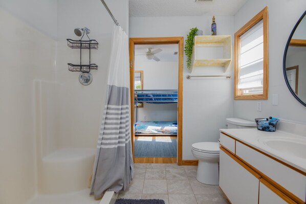 Un baño con ducha, inodoro y lavamanos.