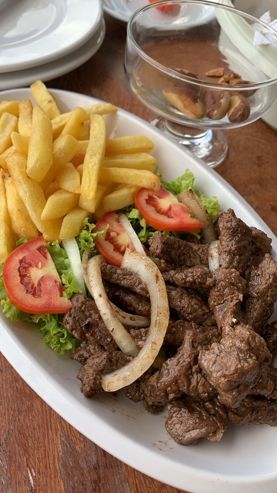 A plate of food with beef, fries, and salad.