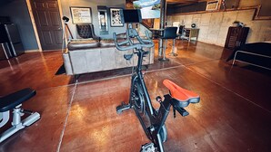 A spacious room with a large exercise bike, a sofa, and a dining area. - Amazing view and location (Springfield)