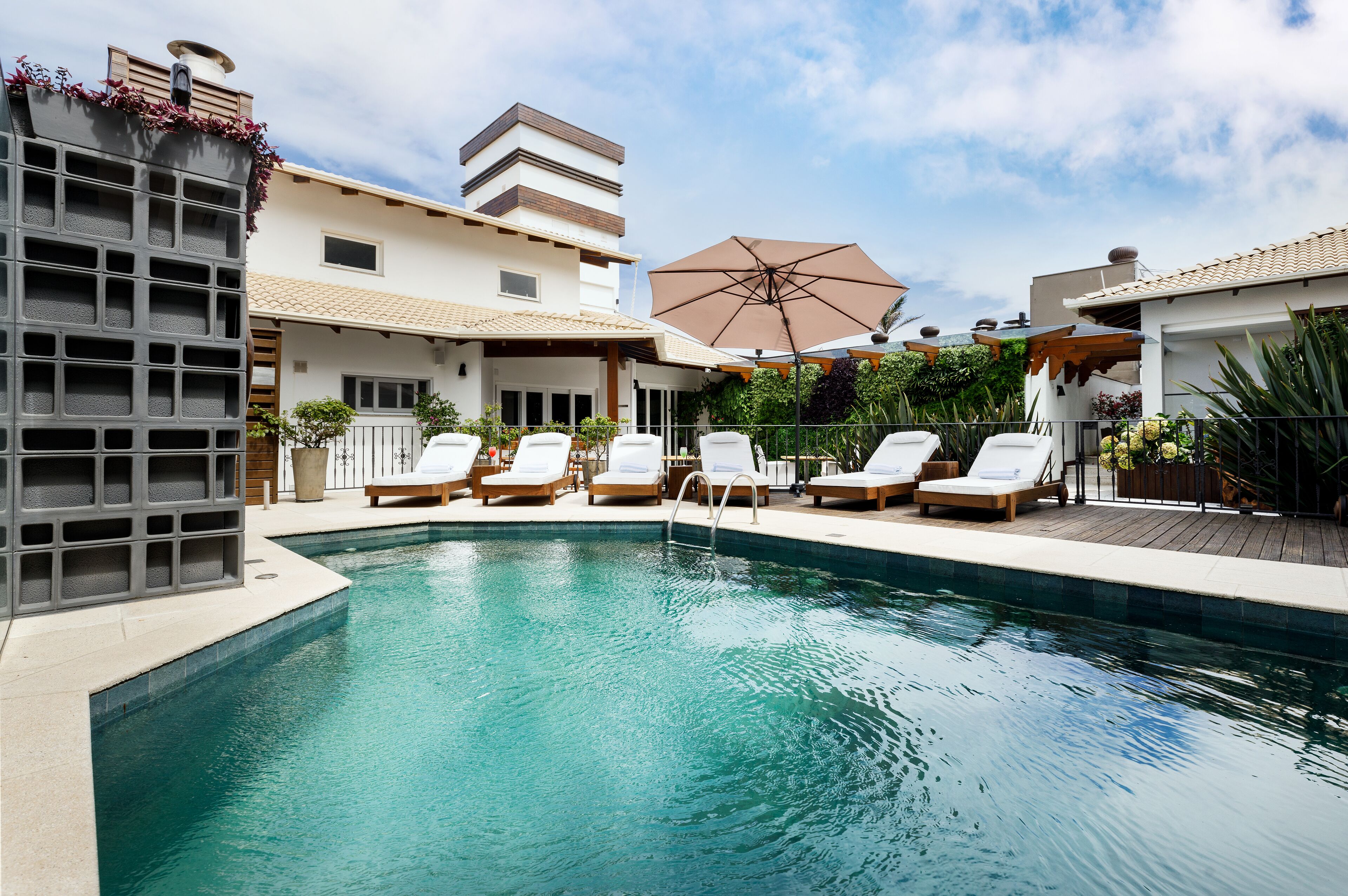 Une piscine avec des chaises longues et une pergola.